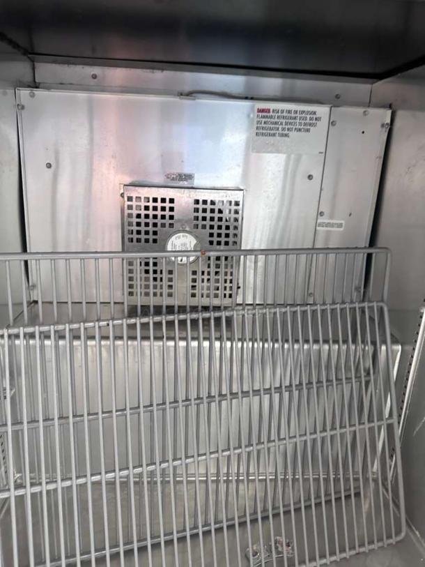 True TUC-27F-LP-HC undercounter freezer interior, stainless steel, fully operational. Includes shelving and caution label.