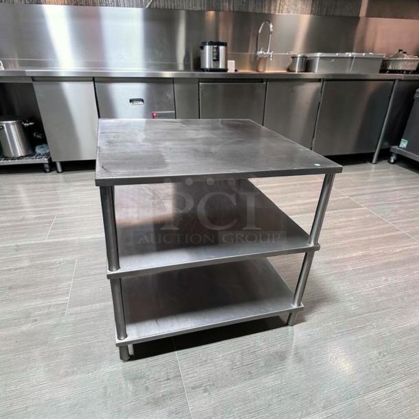 34" x 34" stainless steel commercial work table with double shelves, in superior condition, heavy-duty for food prep.