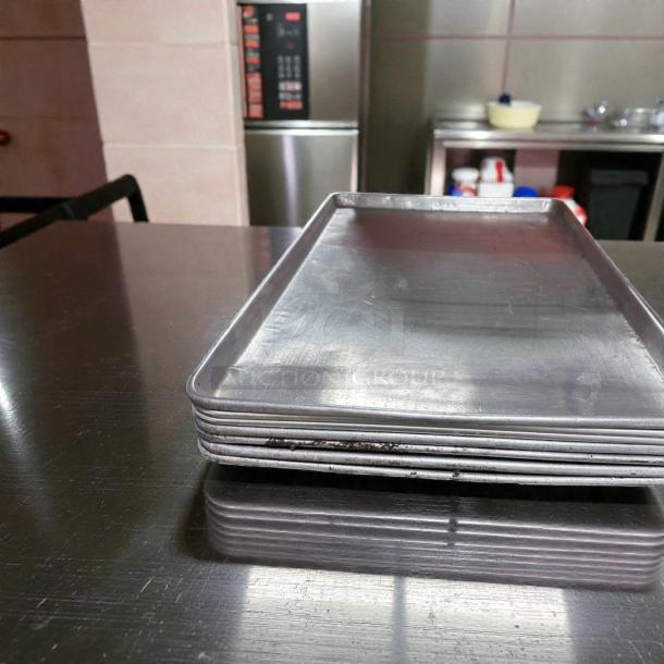 Seven Winco ALXP-1826 full-size sheet pans, 26"x18", 18-gauge aluminum. Outstanding condition, ideal for commercial use.