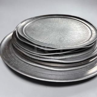 Stack of commercial aluminum round pizza pans in various sizes, heavy-duty, restaurant grade, unbranded, in superior condition.