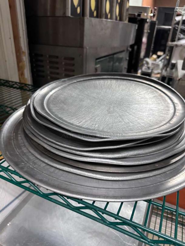 Unbranded commercial aluminum round pizza pans in excellent condition, heavy-duty, multiple sizes, restaurant grade.