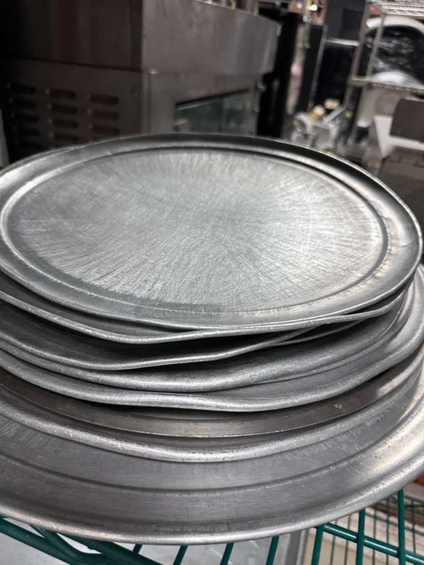 Lot of commercial aluminum round pizza pans in superior condition, unbranded, heavy-duty, various sizes, restaurant grade.