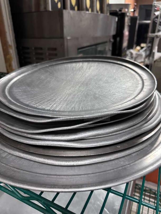 Lot of round aluminum pizza pans in superior condition, heavy-duty, various sizes, unbranded, restaurant grade.
