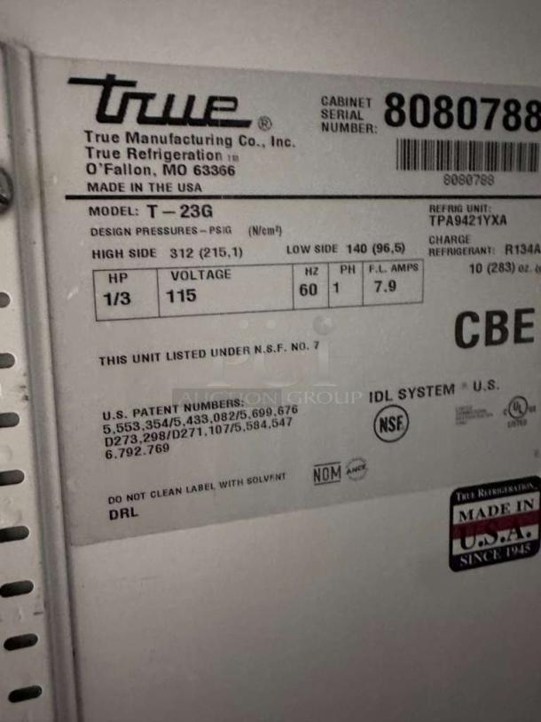 Label on True T-23G-HC commercial refrigerator showing model, voltage (115V), serial number, and NSF certification.