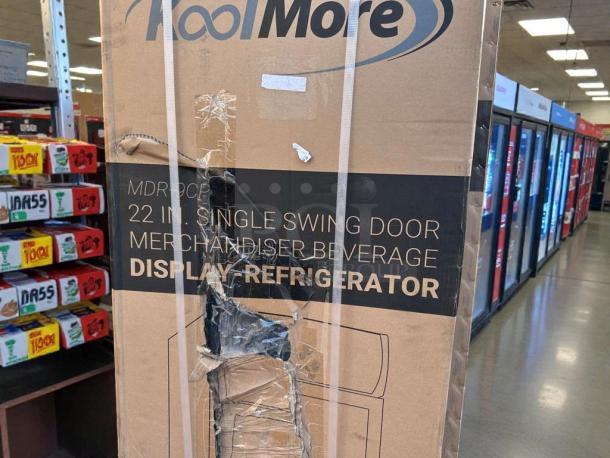 Brand new KoolMore MDR-9CP electric merchandiser refrigerator in box. Box shows visible damage; refrigerator condition unknown.