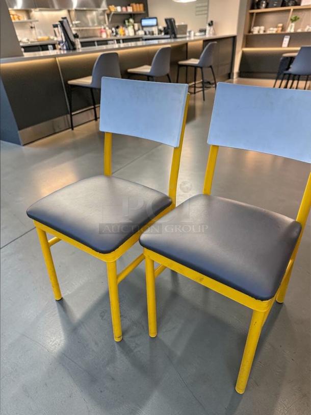 Commercial Grade dining chairs with yellow heavy-duty metal frame and gray upholstered seats and backs. Model: FUR-M-CHR-0583.