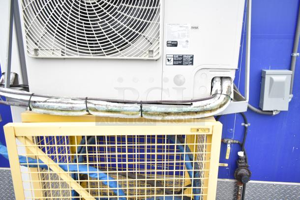 Commercial mobile kitchen trailer's external CaptiveAire ventilation system with visible wiring and protective cage.