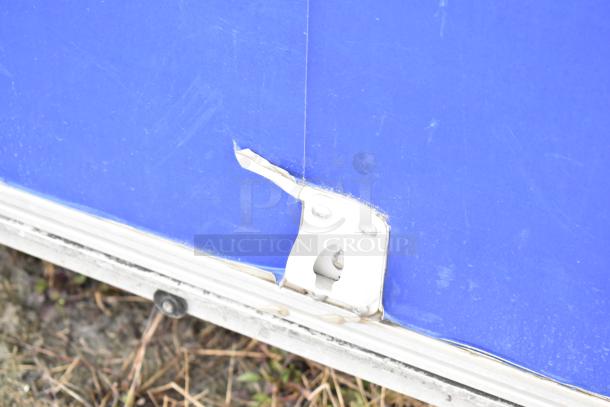 Close-up view of a blue mobile kitchen trailer exterior, showing a metal latch and edge wear.
