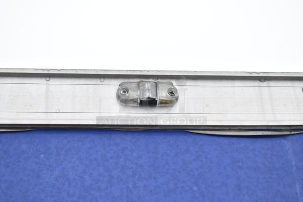 Commercial mobile kitchen trailer exterior detail, showing part of the frame with mounted hardware.