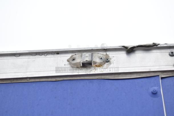 Commercial mobile kitchen trailer exterior showing upper section detail with aluminum frame and fastening screws.