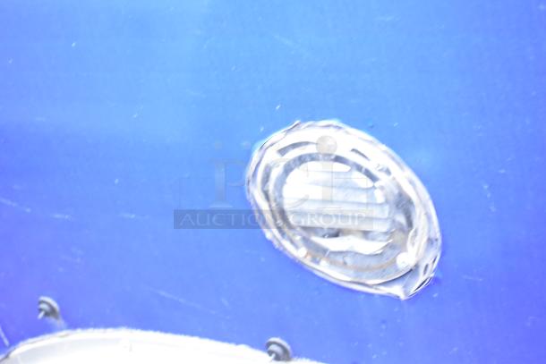 Exterior detail of a blue commercial mobile kitchen trailer showing a circular light fixture.