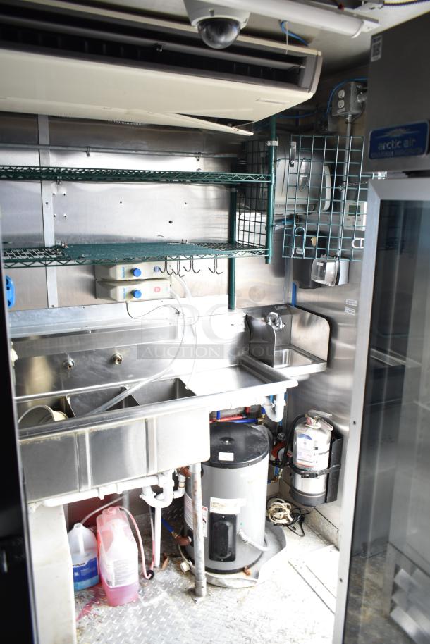 Commercial mobile kitchen trailer interior with CaptiveAire hood, Pitco fryers, stainless steel sinks, and Arctic Air refrigeration.
