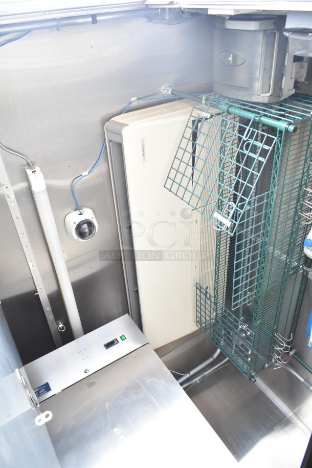 Commercial mobile kitchen trailer interior with CaptiveAire hood, Pitco propane fryers, refrigeration unit, and wiring.