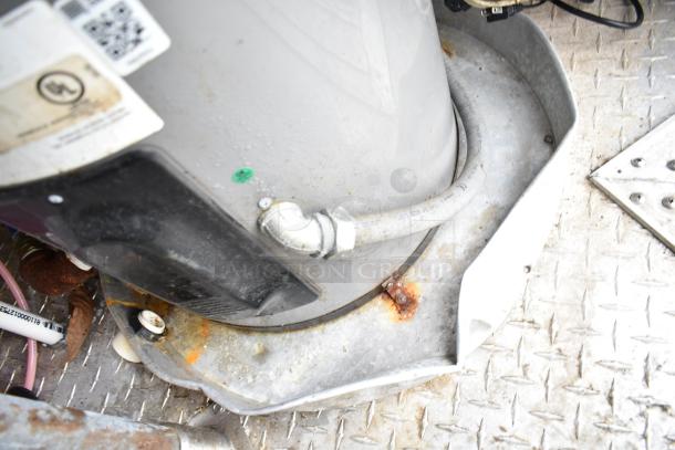 Close-up of a component inside the commercial mobile kitchen trailer, showing part of the ventilation or gas line system, with visible wear and rust on metal surfaces.