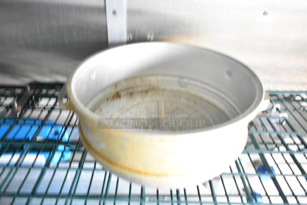 Alt text: Close-up of a kitchen component in a mobile kitchen trailer. Shows a metal pan sitting on a wire shelf.