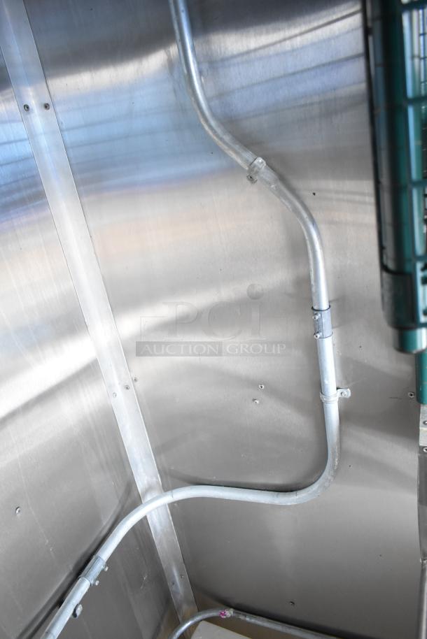 Interior wall of a commercial mobile kitchen trailer showing metal piping, showcasing pristine metal finish and craftsmanship.