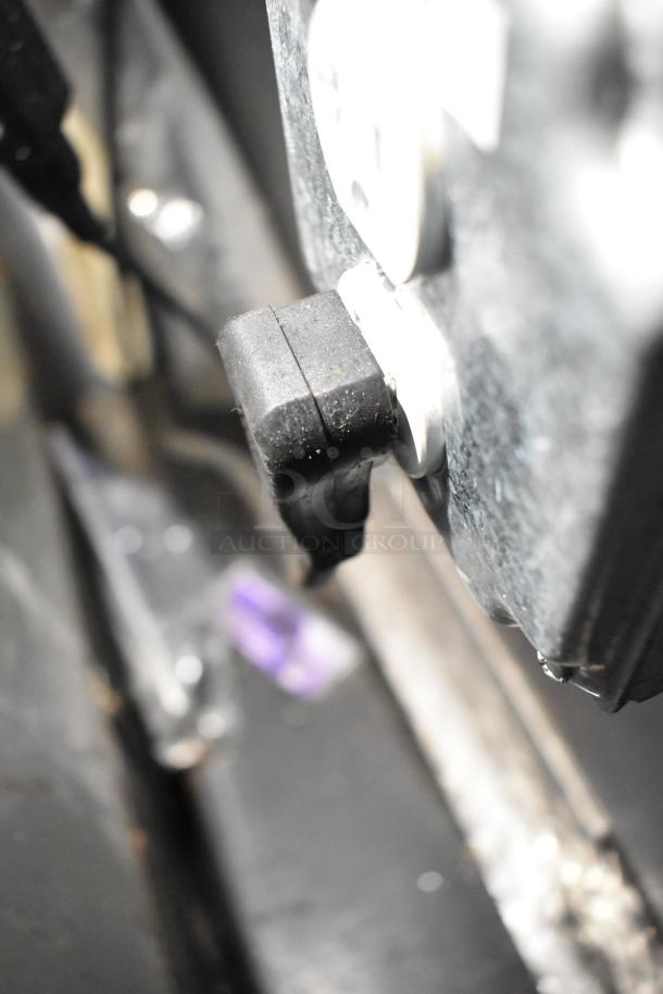Power outlet with black plug connected in a commercial mobile kitchen trailer.
