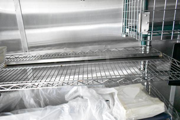 Interior view of a commercial mobile kitchen trailer, featuring stainless steel shelving and storage space, in excellent condition.