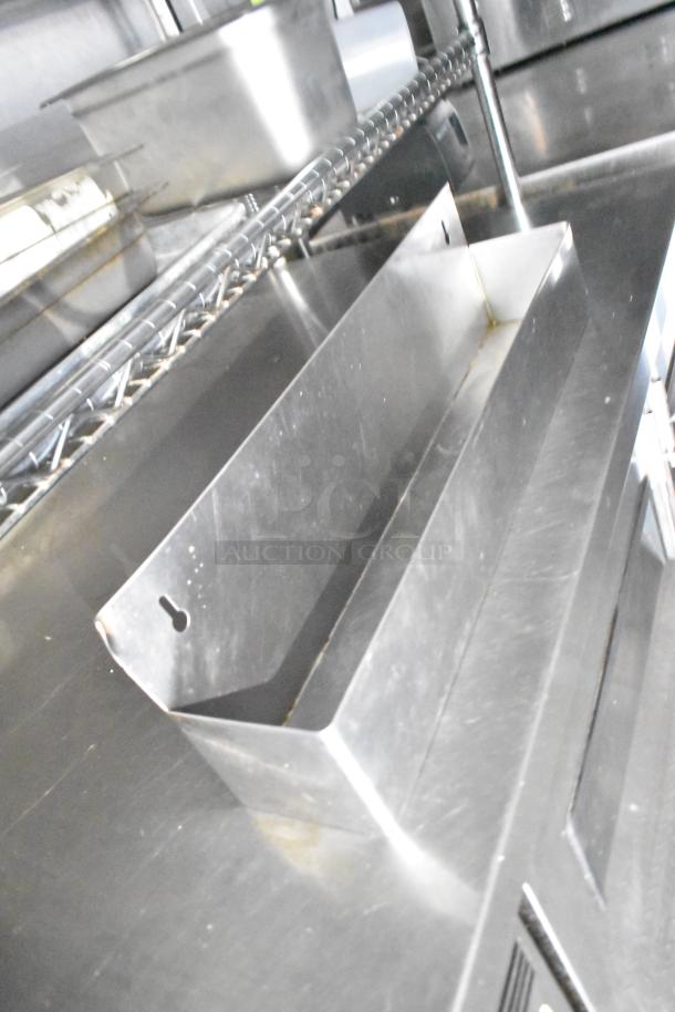 Commercial mobile kitchen trailer interior showing stainless steel shelving and equipment, indicating durable construction.