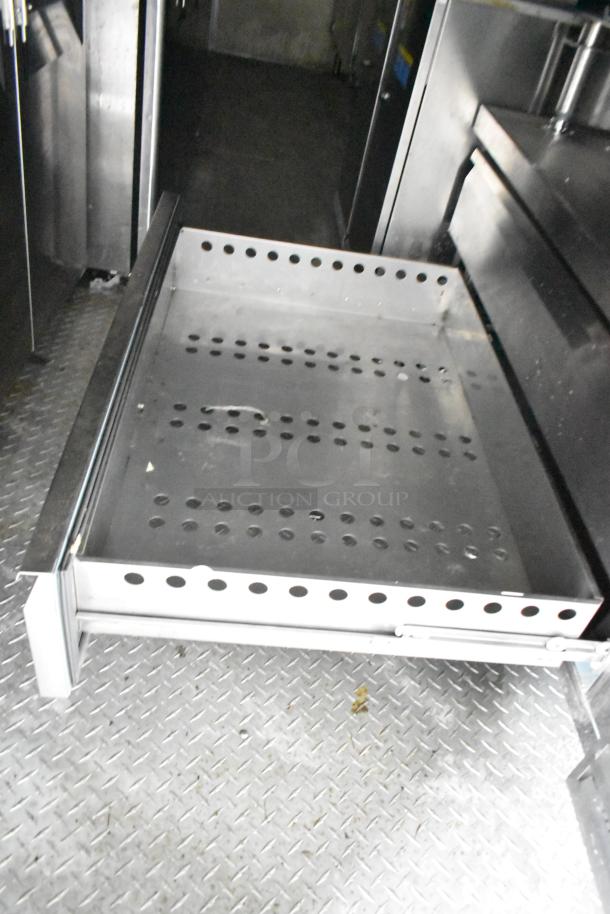 Commercial mobile kitchen trailer interior with CaptiveAire hood, Pitco propane fryers, and complete refrigeration visible.