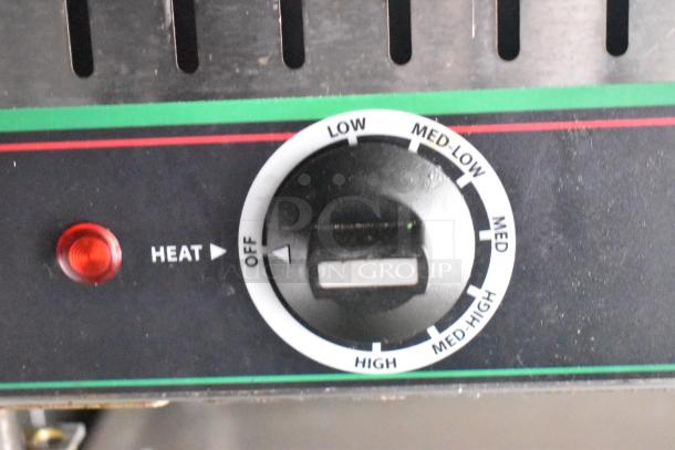 Thermostat control knob on a commercial mobile kitchen appliance, featuring adjustable heat settings from low to high.