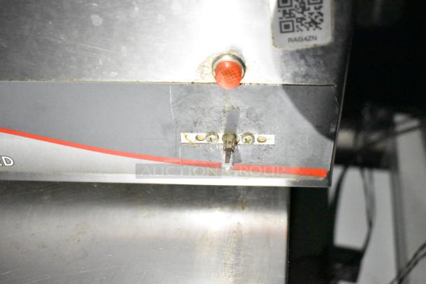Commercial mobile kitchen trailer detail showing metal surface with a red button and QR code label.