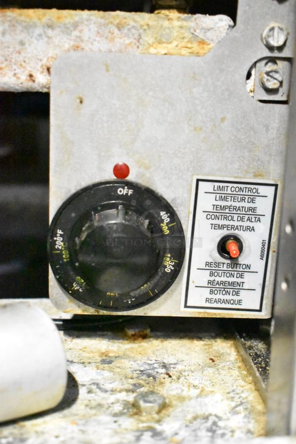 Temperature control panel on a commercial mobile kitchen trailer with settings up to 220°F. Includes reset button with multilingual label.