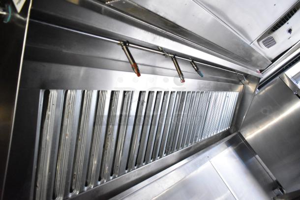 Commercial mobile kitchen trailer interior with CaptiveAire hood system, stainless steel finish, and visible ventilation components.