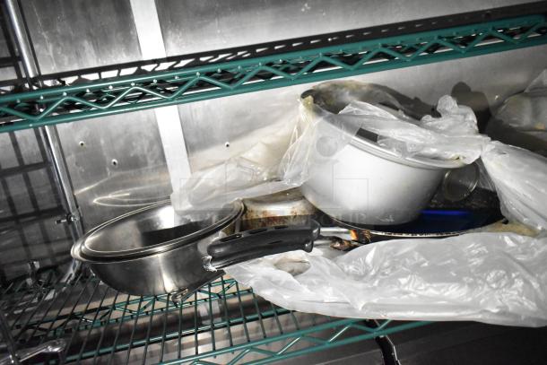 Fully equipped mobile kitchen trailer with CaptiveAire hood, Pitco propane fryers, refrigeration, cookware on wire shelf.