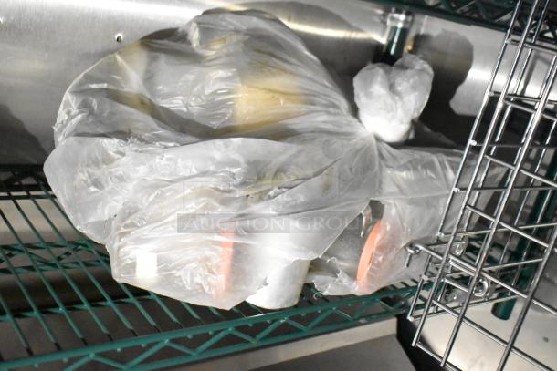 Plastic-wrapped food items stored on a metal shelving unit inside a commercial mobile kitchen trailer.