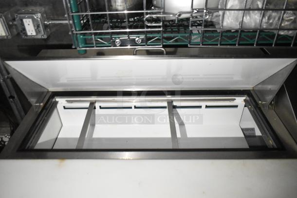 Commercial mobile kitchen trailer interior with open metal refrigeration unit, sturdy shelves, and CaptiveAire hood system.