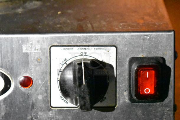Control panel of a commercial mobile kitchen trailer with temperature dial and power switch, indicating functionality.