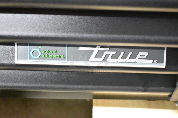"True" logo and "natural refrigerant" label on TVM-48SL-HC commercial cooler, 115V, 1 phase, new with scratches and dents.