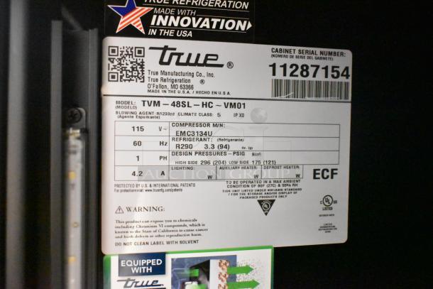 BRAND NEW True TVM-48SL-HC Cooler, scratch & dent, 2-door, 115V, 1 phase, label showing specifications and serial number.