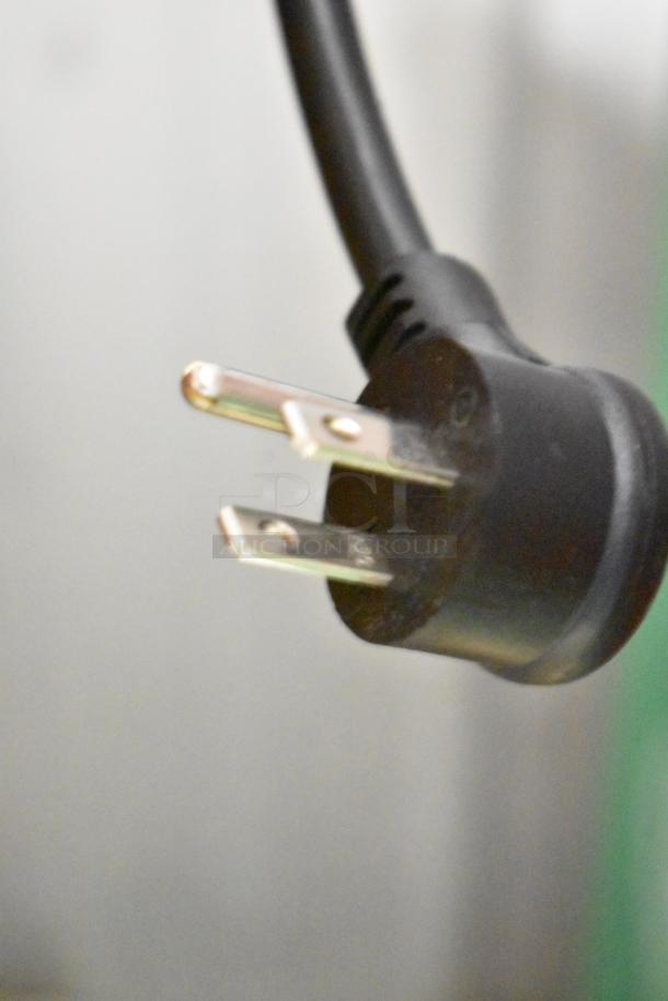 Close-up of a 115V power cord plug for the True TVM-48SL-HC cooler merchandiser.