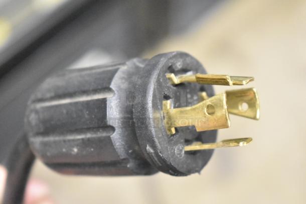 Close-up of electrical plug for a 2018 True GDM-72F-HC commercial freezer, showing prongs and black casing.