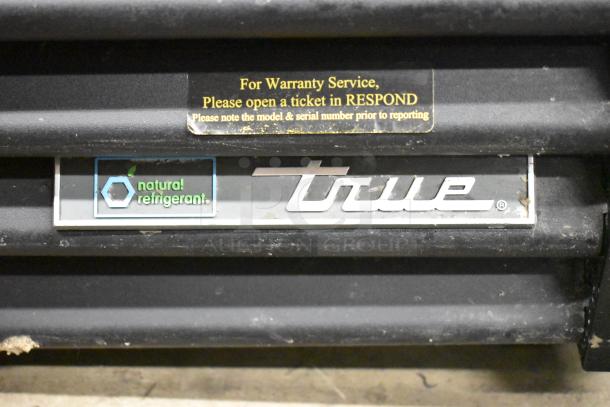 2020 True GDM-49-HC cooler merchandiser base with "natural refrigerant" label and warranty service instructions.