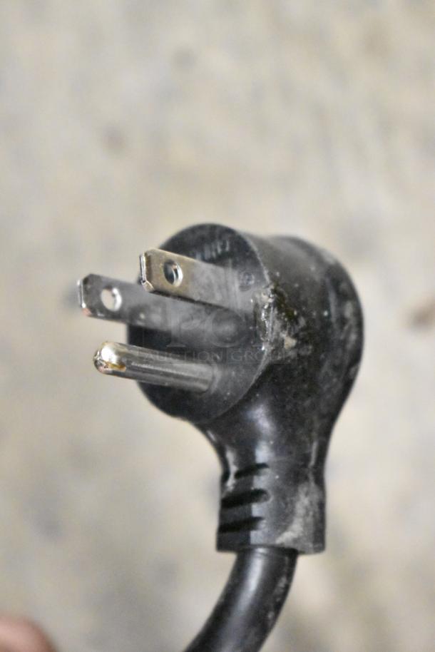 Close-up of a three-prong electrical plug attached to the 2020 True GDM-49-HC cooler, 115 volts, 1 phase.