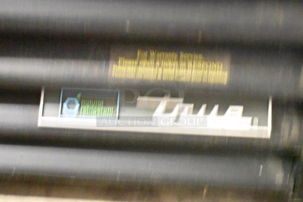 Blurry close-up of a True GDM-49F-HC commercial cooler label, showcasing brand and natural refrigerant information.