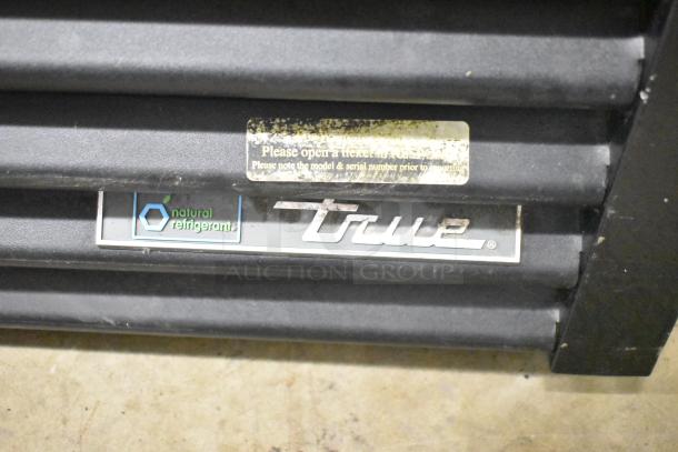 Close-up of True GDM-49-HC cooler label. Features "True" logo, "natural refrigerant" mark, and maintenance instructions.