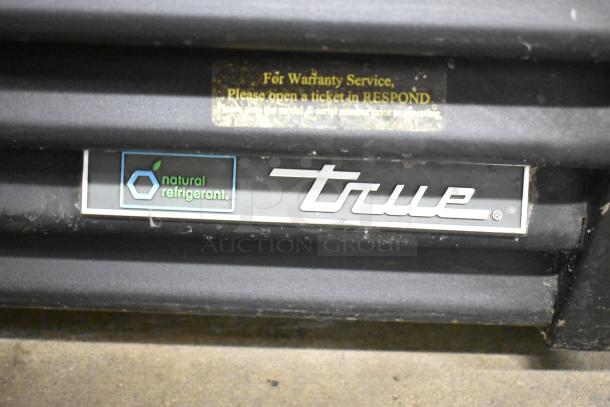 2018 True GDM-72-HC Cooler, 3-door, 115V, natural refrigerant label, warranty info tag visible.