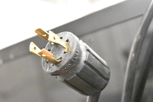 Close-up of the power plug for True GDM-72F-HC commercial 3-door freezer, showing a robust three-prong connector.