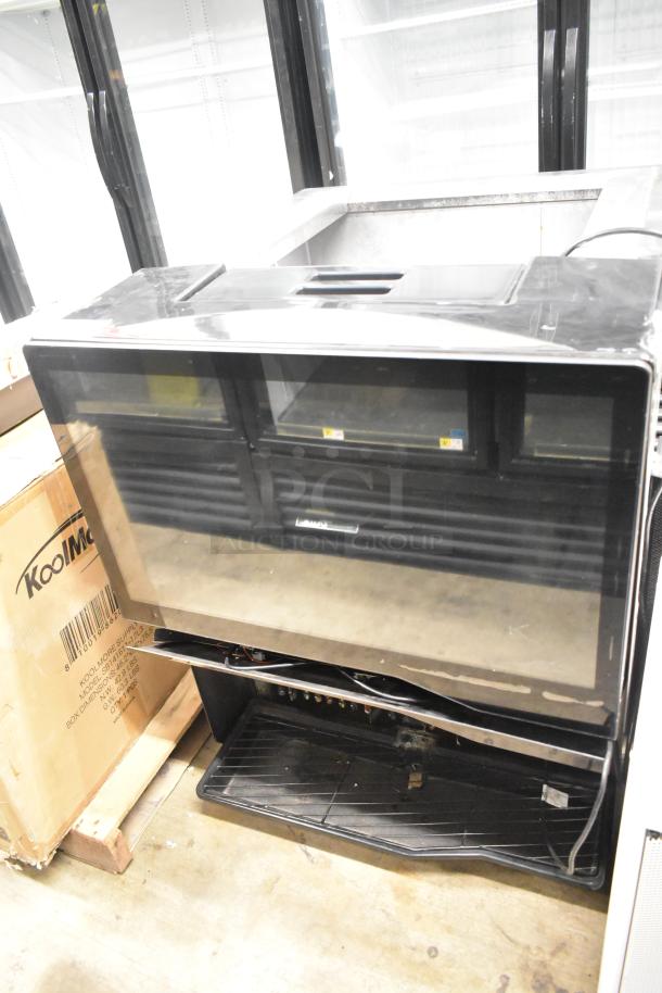 Commercial countertop beverage dispenser, black, glass front, 115 volts, 1 phase, used condition, KoolMore label visible.