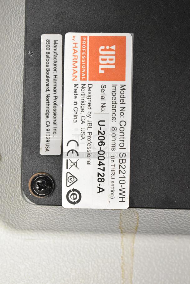 JBL Control SB2210-WH speaker label showing model, impedance, and serial number details.