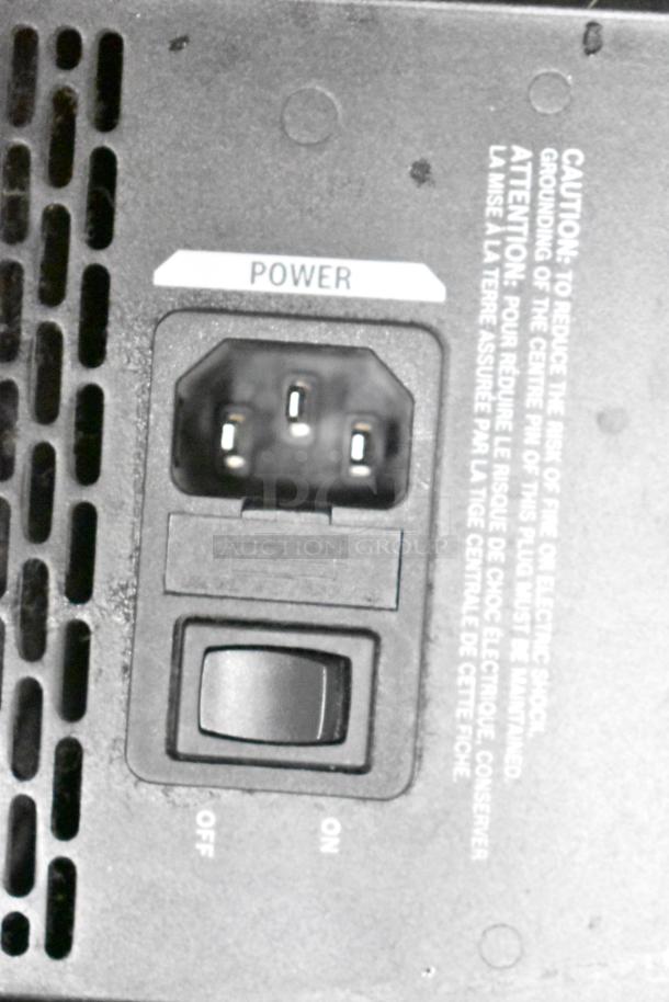 Close-up of power switch and caution label on a JBL speaker. Switch shows "ON" and "OFF" positions.