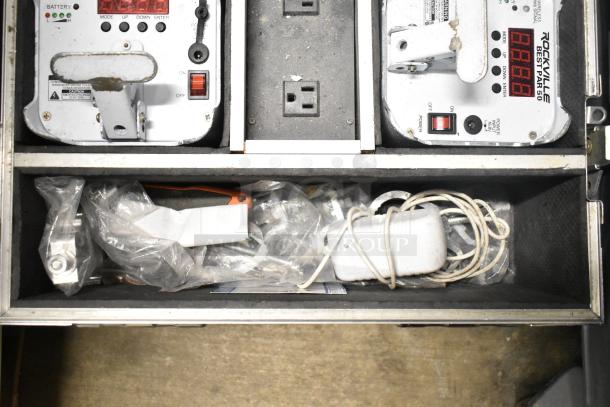 Hard case containing JBL Control 25AV speakers, Rockville Best Par 50 lights, and additional lighting equipment.