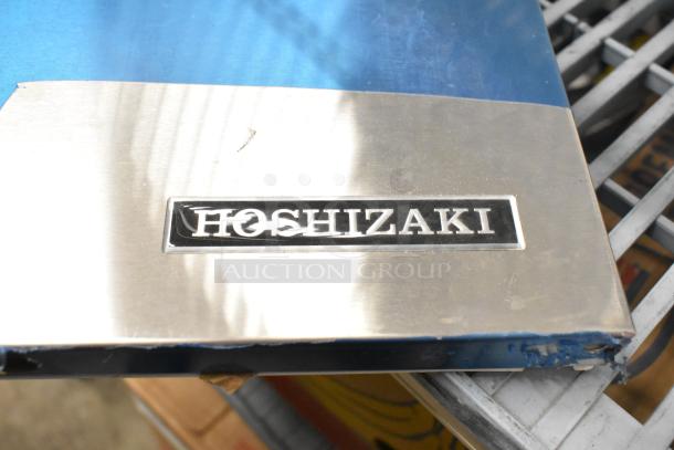 Brand new Hoshizaki ice maker door with visible scratches and minor dents. Silver finish with Hoshizaki logo.