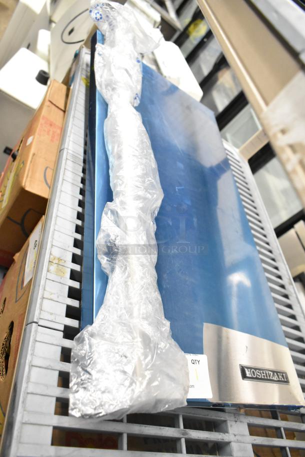 Brand new Hoshizaki ice maker door in pristine condition, partially wrapped. Visible Hoshizaki logo plaque.