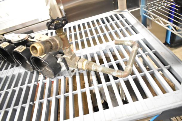 Everpure InsurIce 4000 Water Filtration System, copper pipes, brass fittings, used condition, mounted on a metal rack.