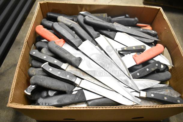 Box of 80 sharpened stainless steel knives, including chef knives, with black and red handles. Worn condition.